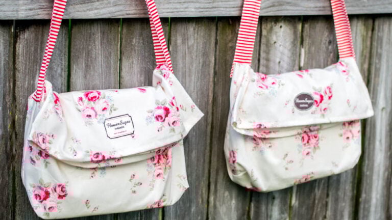 Floral messenger bags on wooden fence