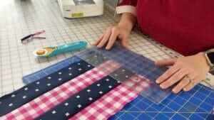 Person measuring fabric with ruler