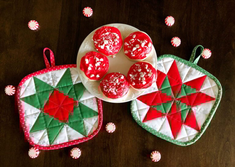 Two handmade quilted Christmas hot pads and a plate of cookies.