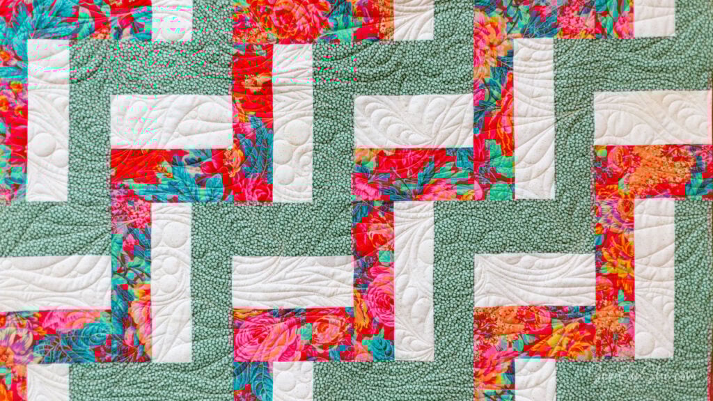 Colorful quilt with rail fence design.