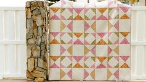 Colorful quilt against a stone wall