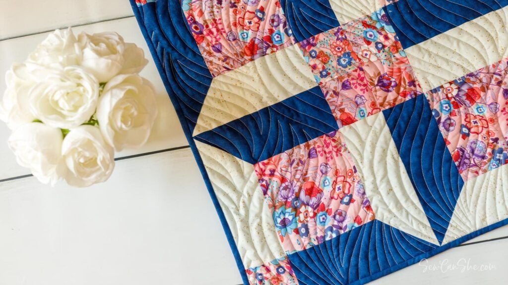 Blue, Pink, and white quilt with spool quilt blocks.