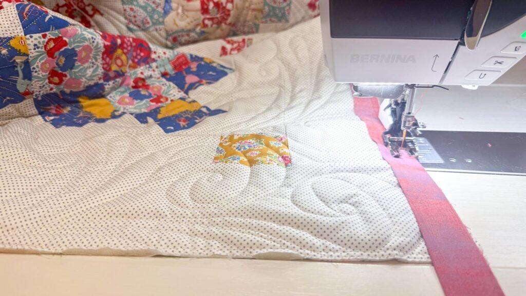 a sewing machine sewing binding to a quilt