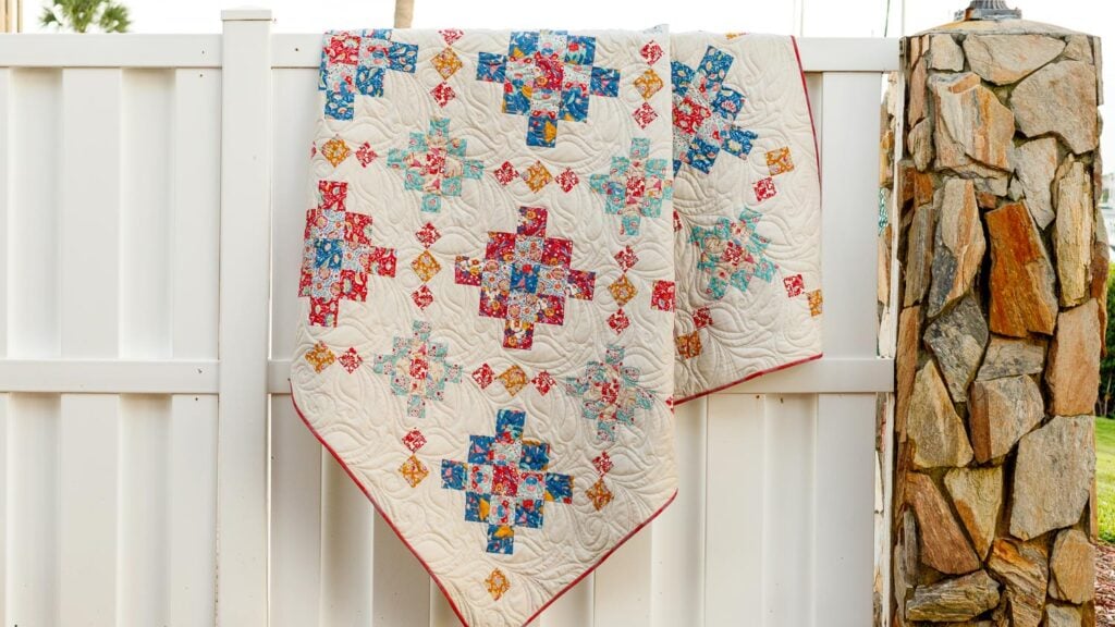granny square quilt draped on fence