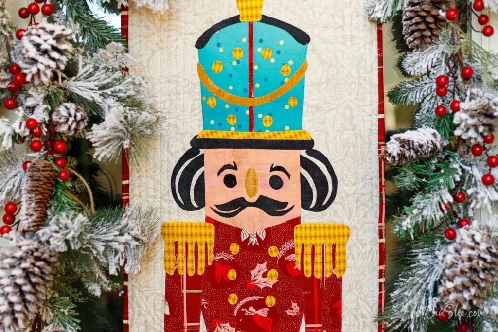 Colorful nutcracker applique design surrounded by decorations