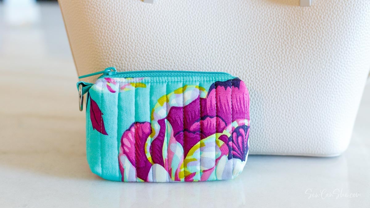 Colorful floral pouch next to leather purse