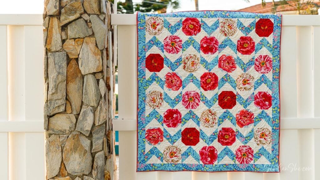 Colorful quilt hanging on fence