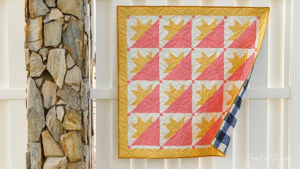 Colorful quilt hanging on fence
