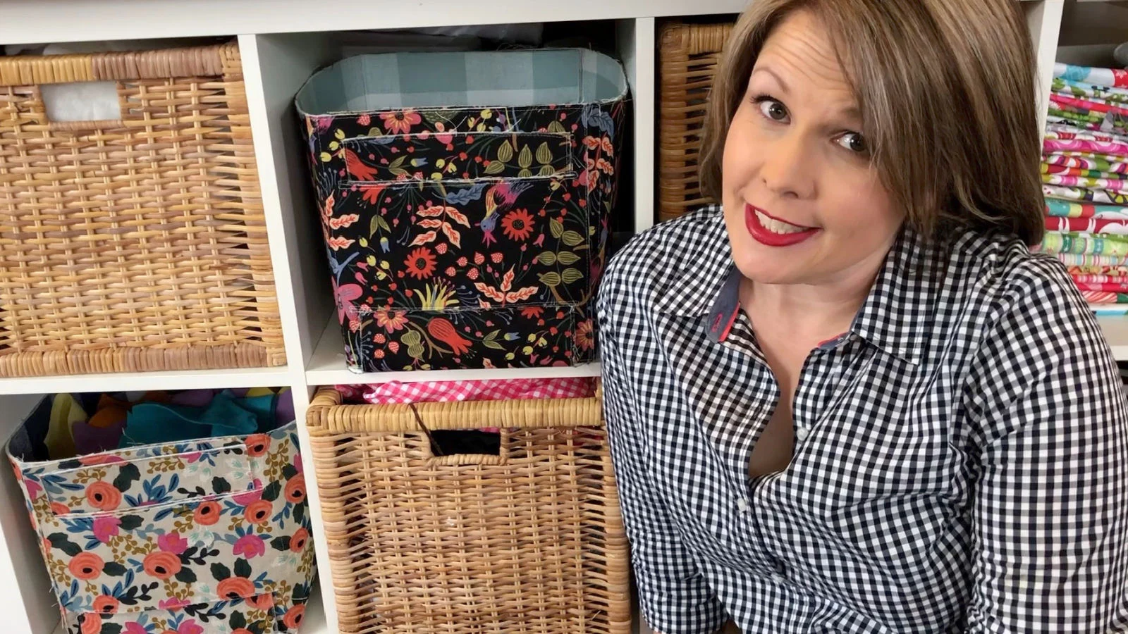 Woman in front of storage bins showing organized fabric.