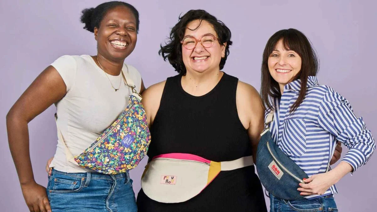 Three women wearing stylish hip bags.