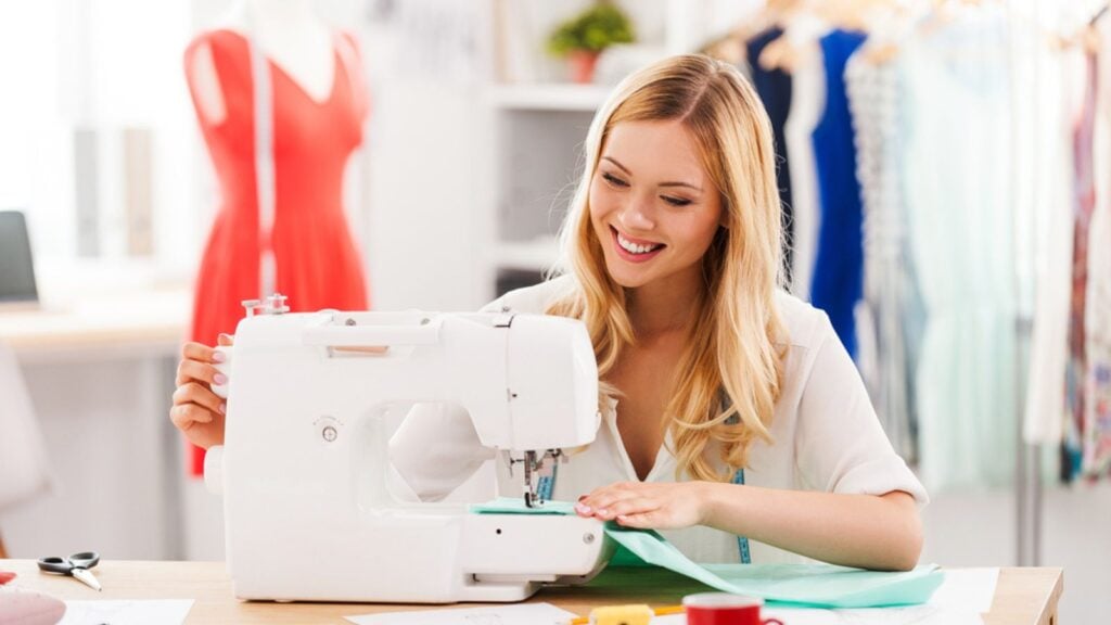 Happy woman using sewing machine