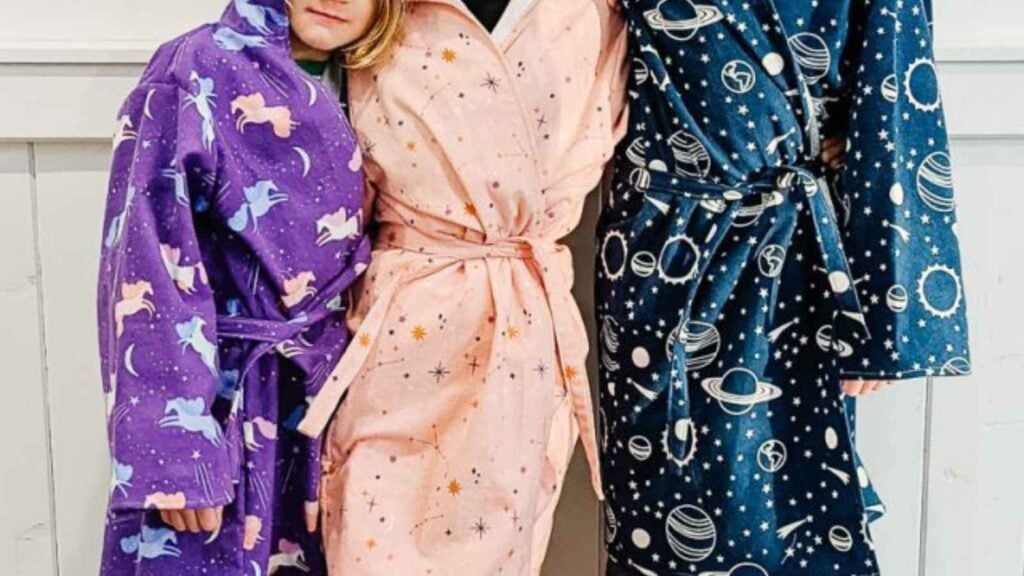 three children modeling colorful hand sewn robes