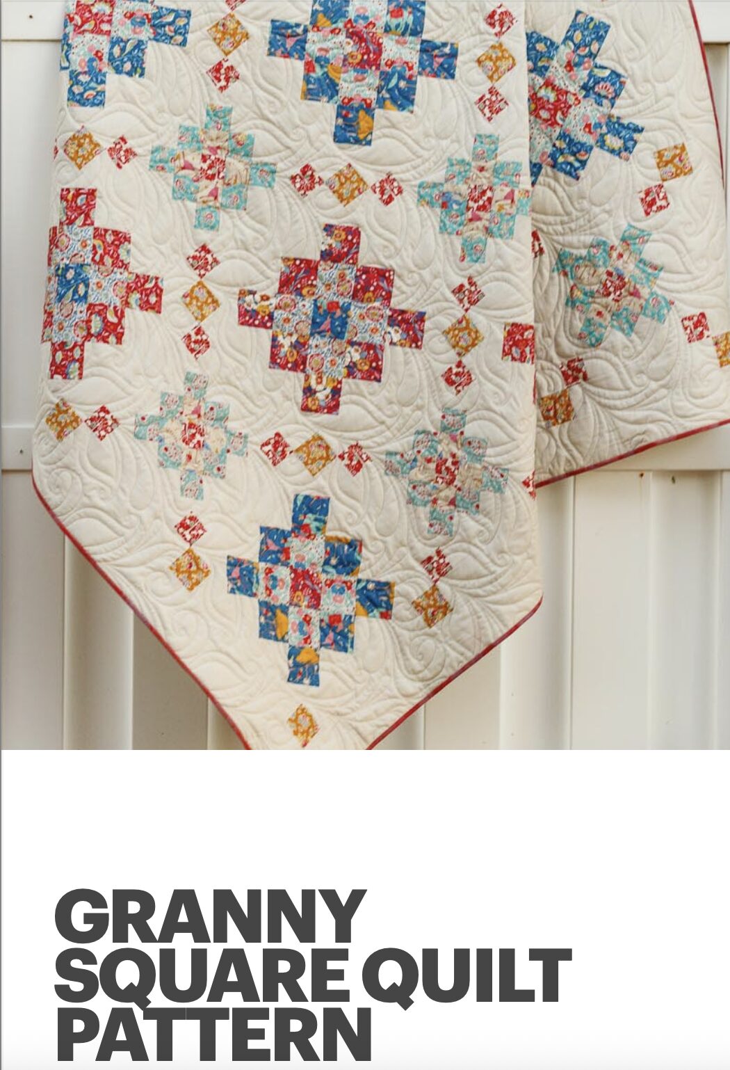 colorful granny square quilt hanging on a fence