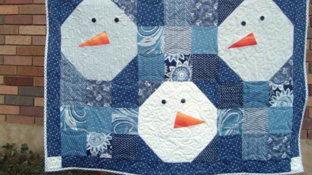 Snowman heads on a blue quilt