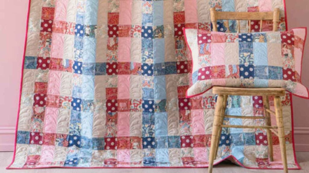 A cozy and structured quilt featuring a large-scale plaid design created with woven-look Tilda prints. The clean, intersecting lines give it a modern farmhouse appeal, making it an inviting "eye candy" piece for a porch swing or a rustic living room.
