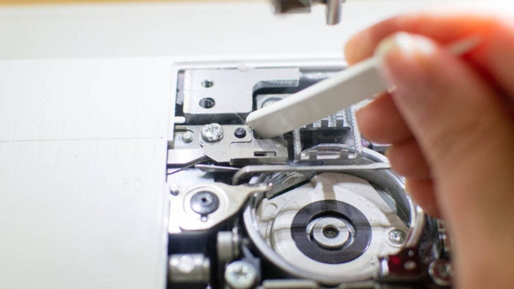 Using Stiff Bristle Brush to Clean Sewing Machine