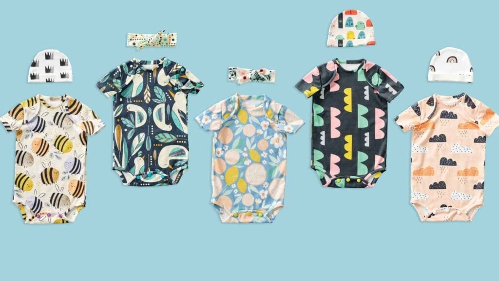 five handmade baby onesies in colorful fabric
