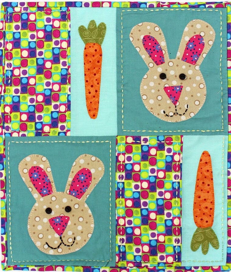 An Easter-themed mini quilt featuring a bunny applique design with spring floral fabric borders.
