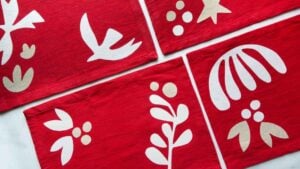 four festive red placemats with white applique
