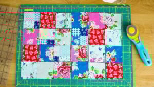 Beginner sewing notions including a green cutting mat, rotary cutter, and fabric on a work surface.