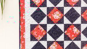 diamond in a square or economy block quilt hanging on a fence