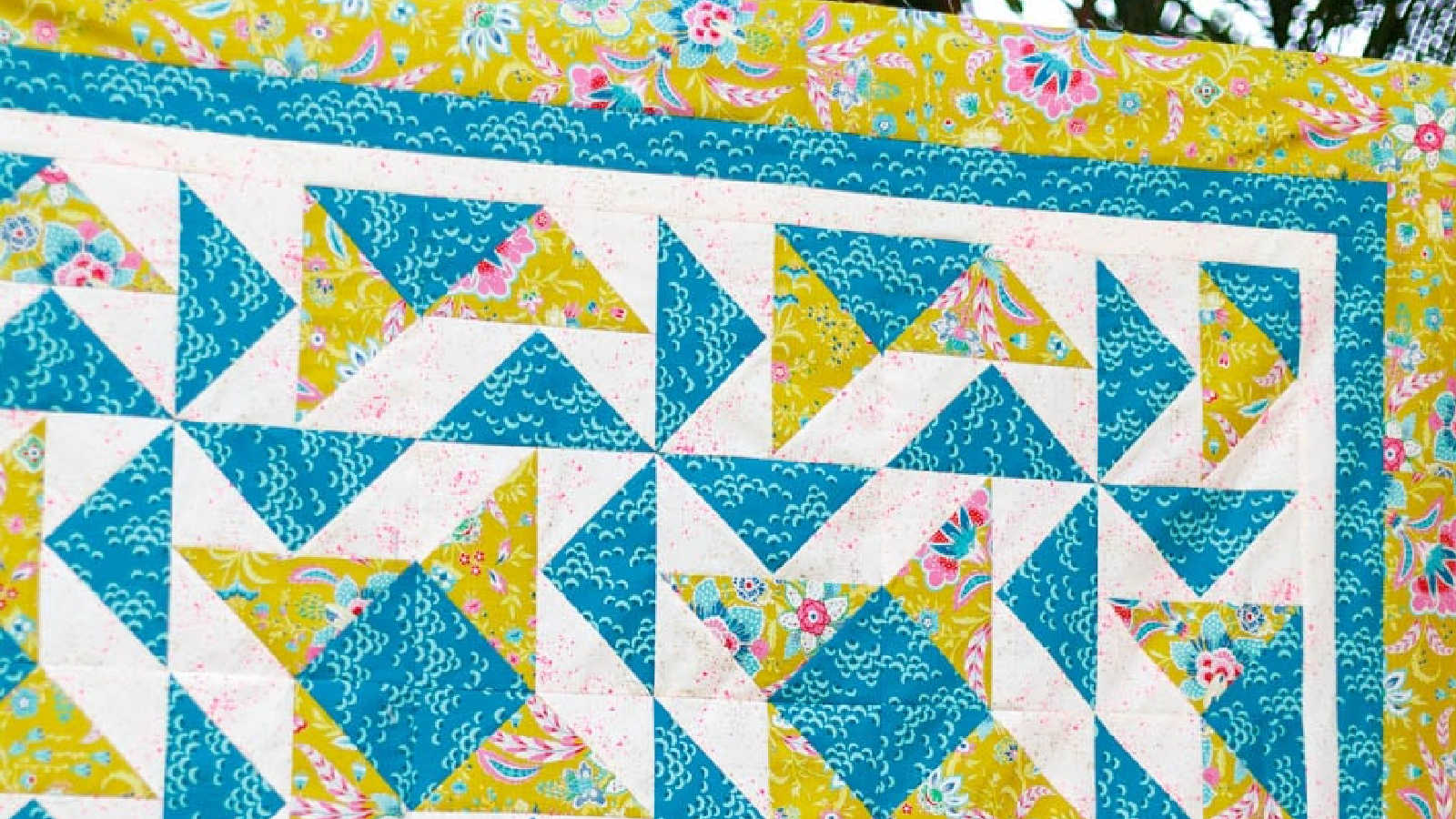 Blue, white, and yellow quilt with dutchman's puzzle design.