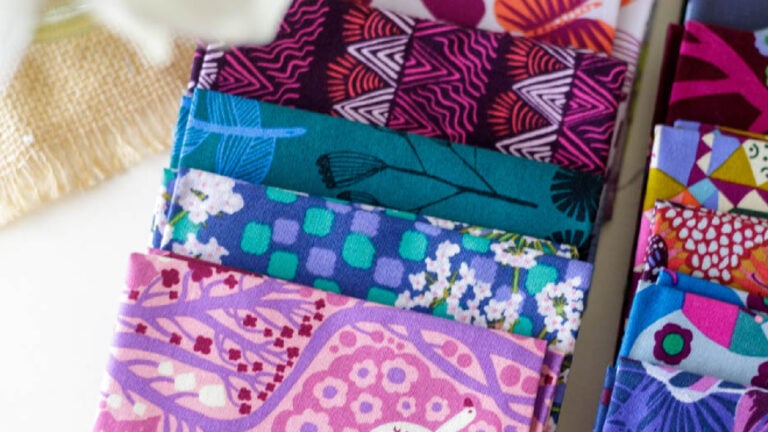 Colorful patterned fabric fat quarters stacked neatly.
