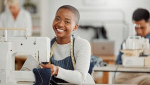 happy woman sewing in classroom