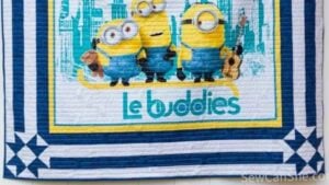 quilted Minion panel quilt with a blue stripe border