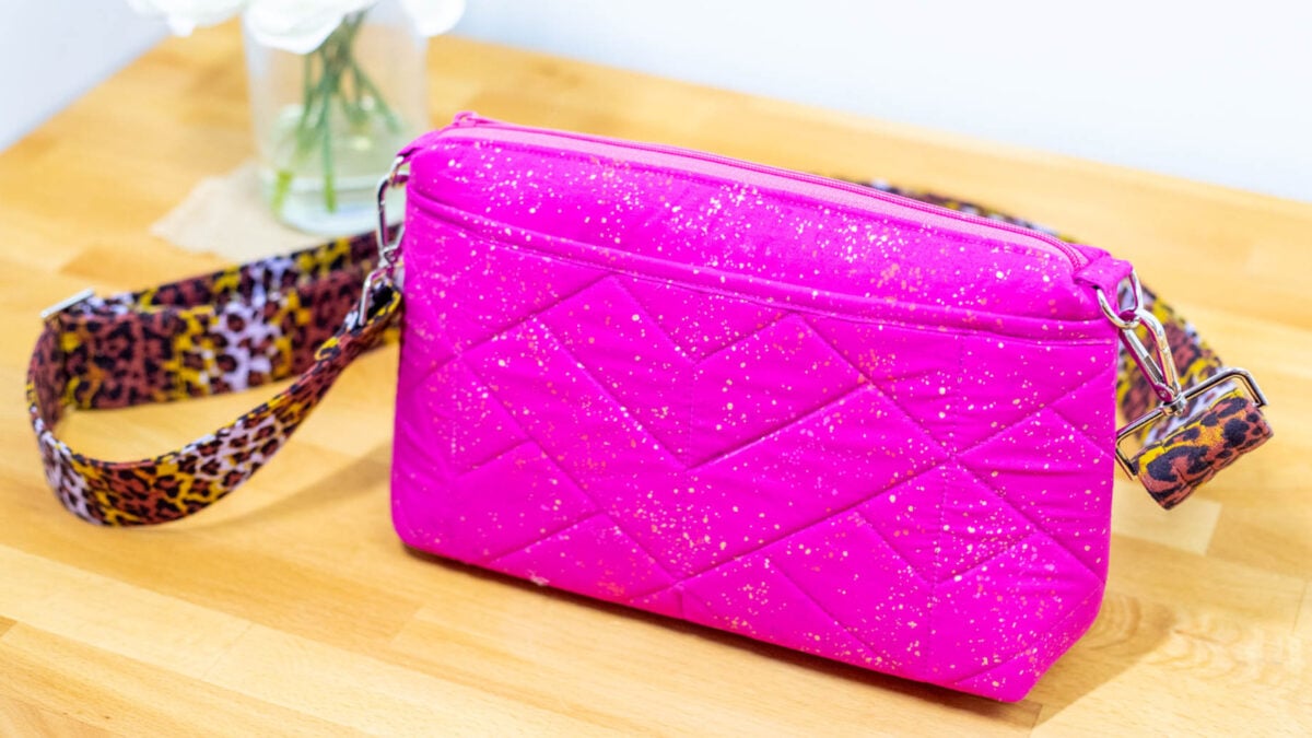 pink quilted crossbody purse with a zipper