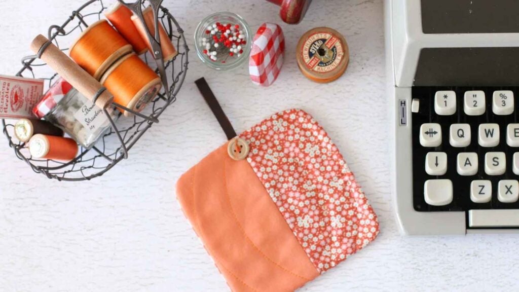 Sewing supplies and a quilted pumpkin coaster to advertise a pumpkin pattern