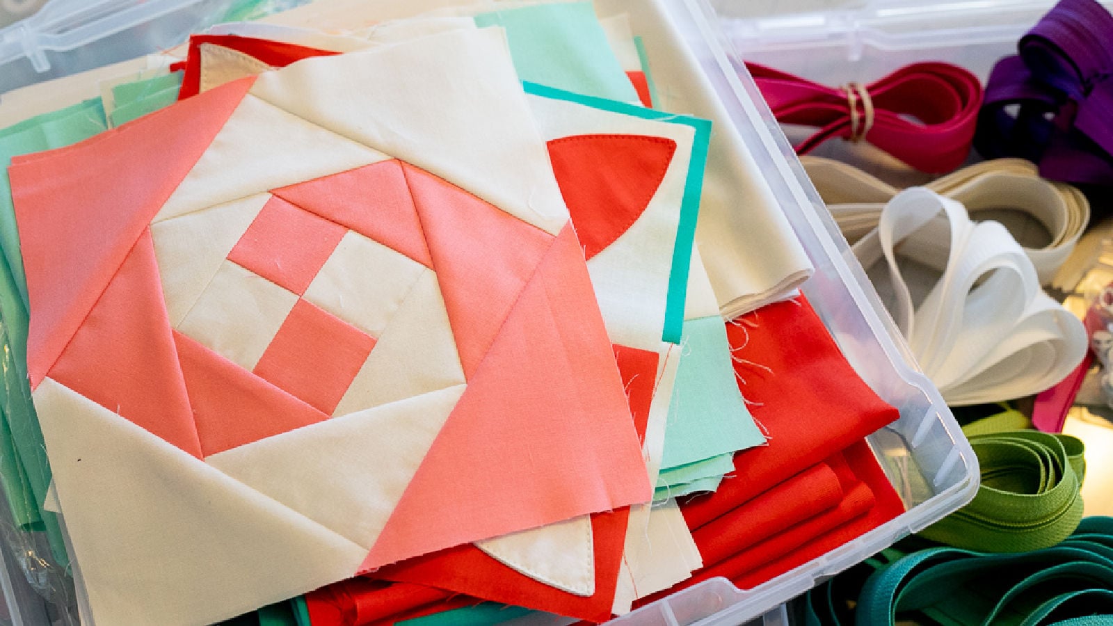 individual quilt blocks in a clear container for storage