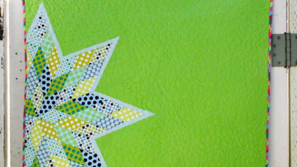 Green quilt with an off center patchwork star
