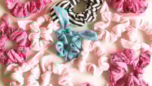 A colorful collection of handmade scrunchies in velvet fabrics, showcasing a modern take on 80s fashion trends and retro sewing patterns.