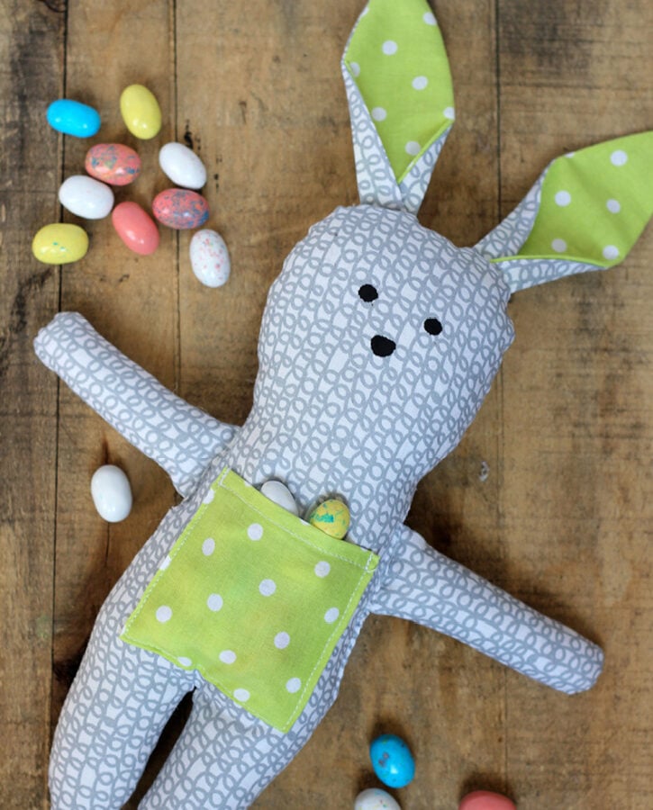 DIY stuffed bunny made from floral cotton fabric featuring a small front pocket and embroidered face details.