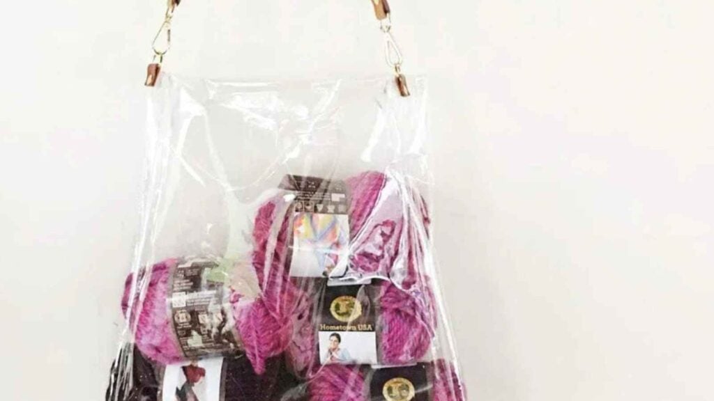 Handmade clear vinyl fabric bag with pink yarn balls inside.